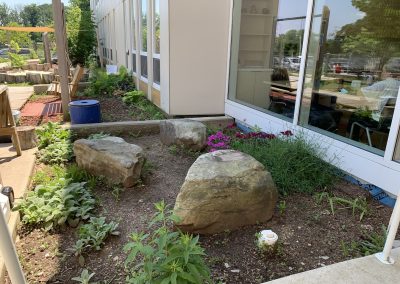 Boulders and plantings at the entry are spot for sitting and balancing