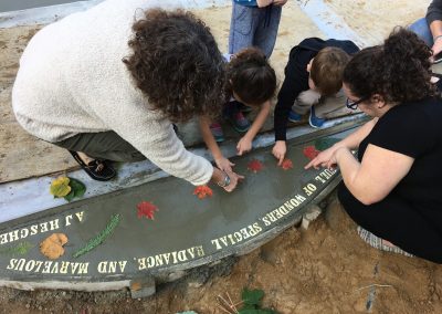 children and adults making concrete imprints